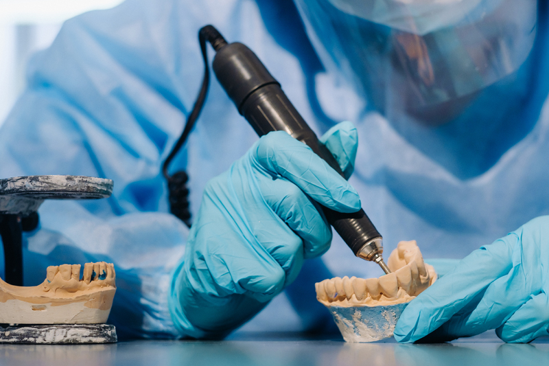 a-masked-and-gloved-dental-technician-works-on-a-p-2025-03-26-19-34-36-utc-1